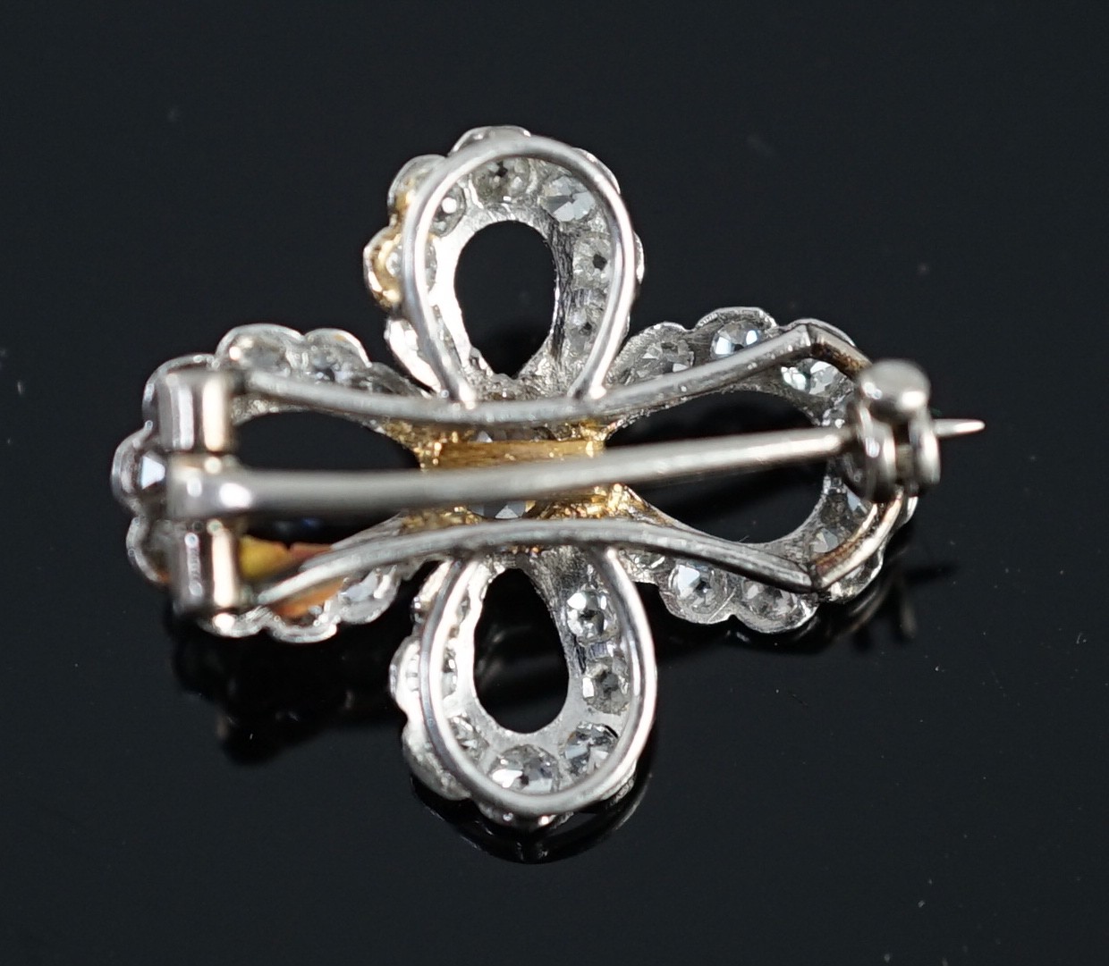 A 1940's white gold? and millegrain set diamond cluster set open work quatrefoil shaped brooch